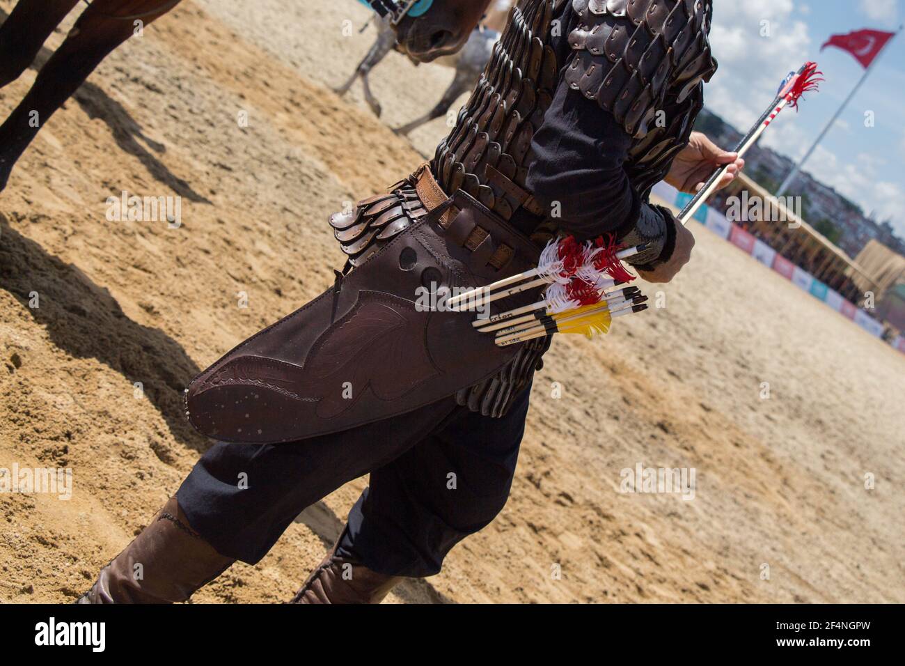 Closeup shot of a spearman with spears on the sand background Stock Photo