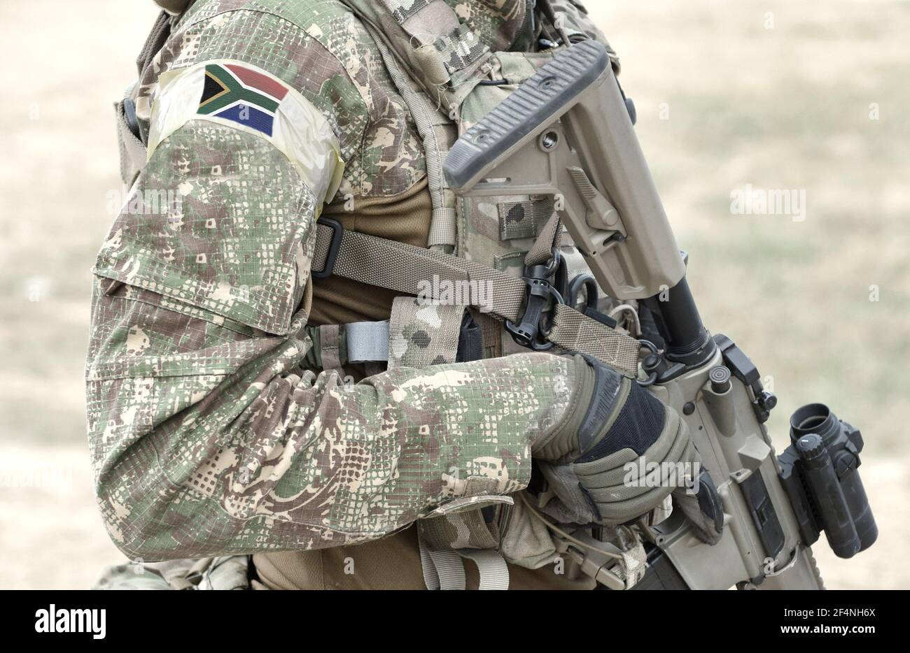 Soldier with assault rifle and flag of South Africa on military uniform ...