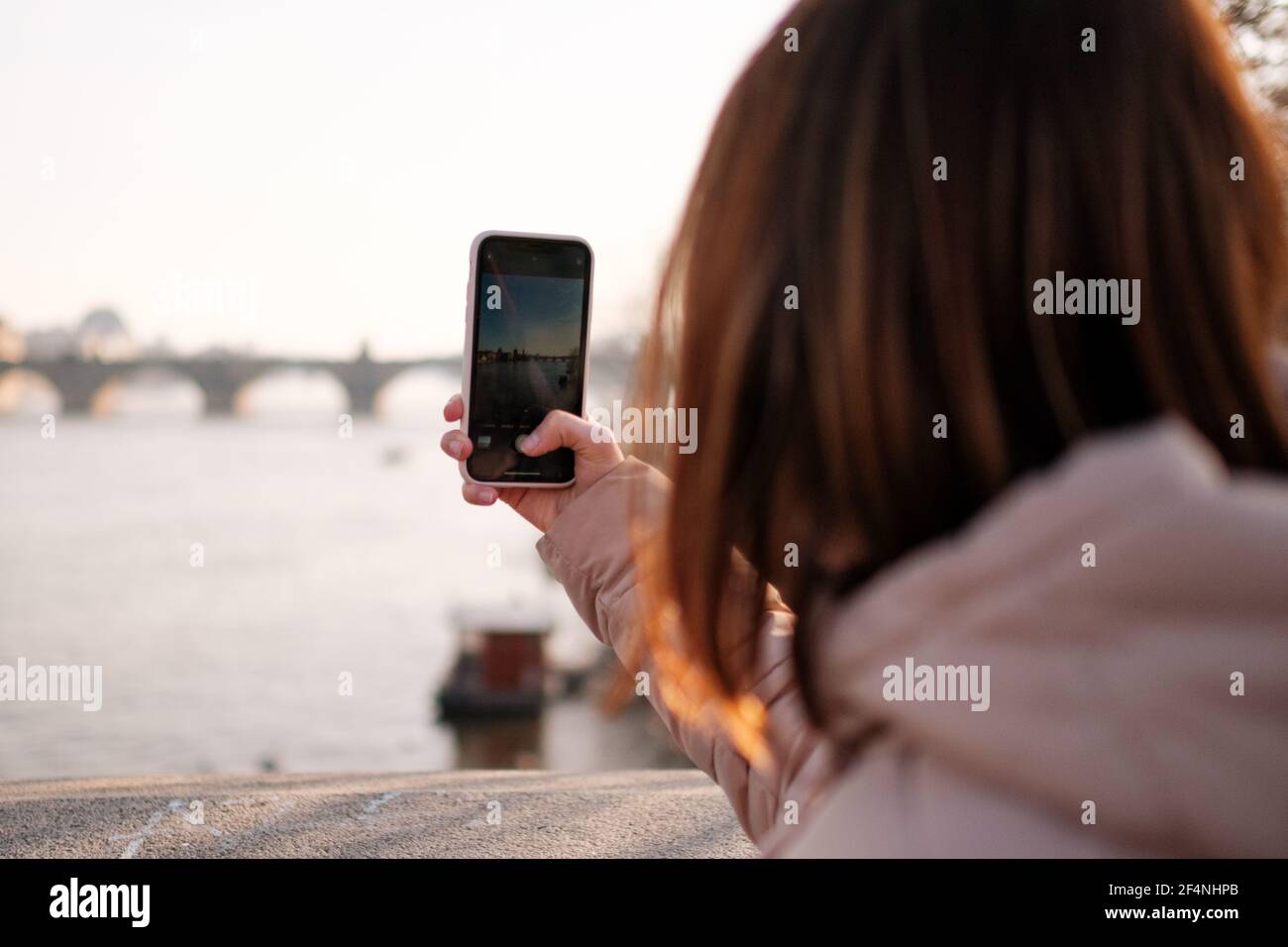 Blogger or influencer recording video from Prague. Vlogger shooting vlog on the mobile phone. Girl makes photo on her smartphone. Travel content Stock Photo