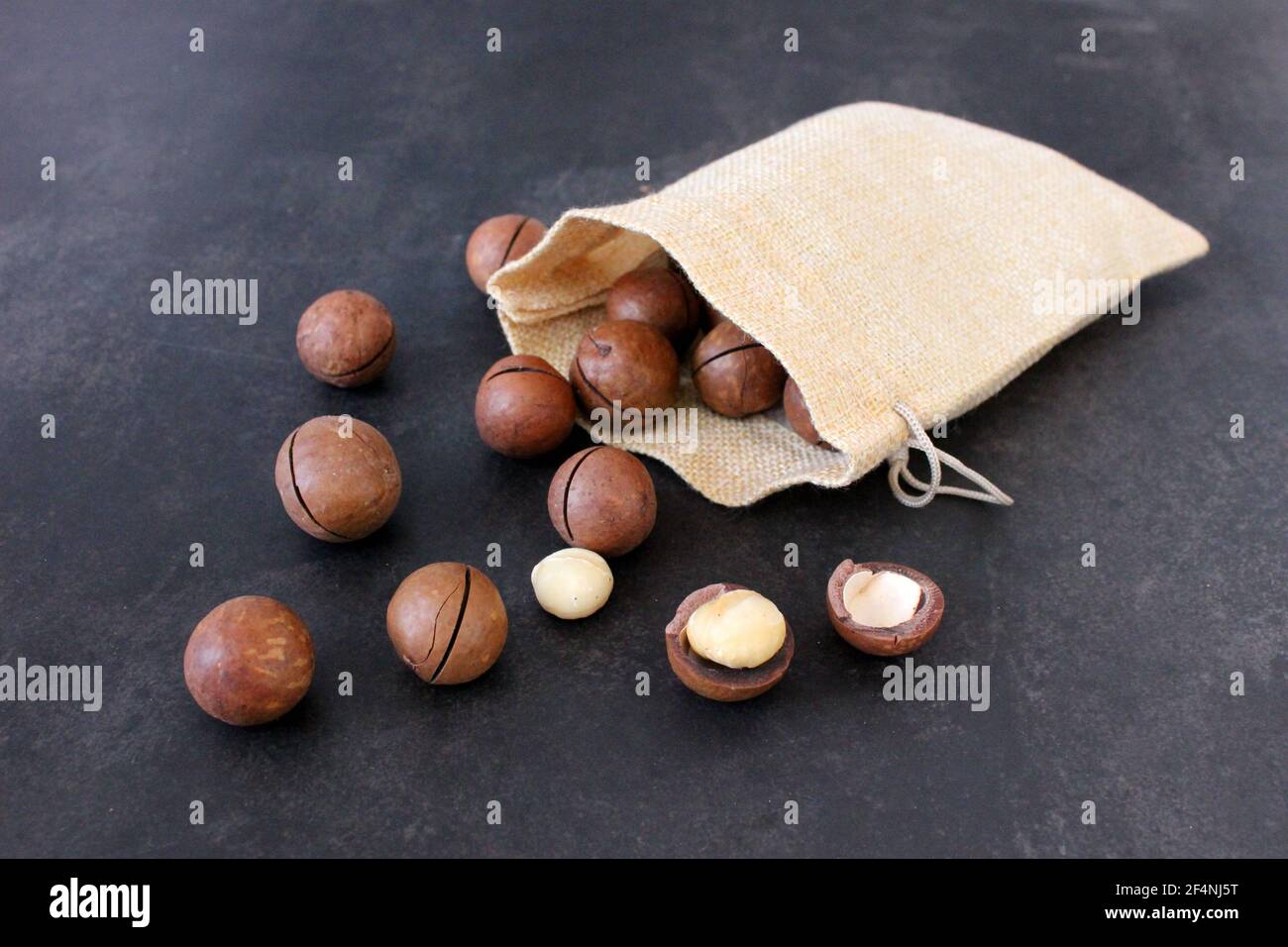 Organic Macadamia nut on dark table Stock Photo