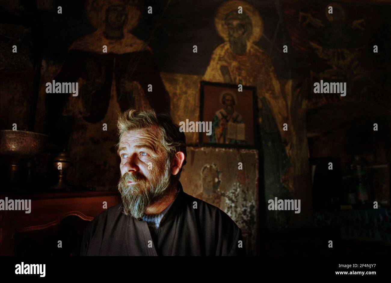 Father Milenko in his 14 century church, one of 13  in the village of Velika Hoca which has to be protected by KFOR and is 100% serb. Stock Photo