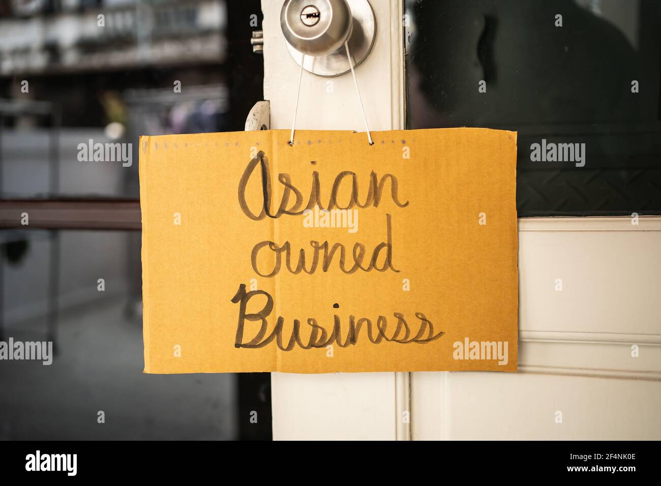 Asian owned business sign was hung on a door knob Stock Photo
