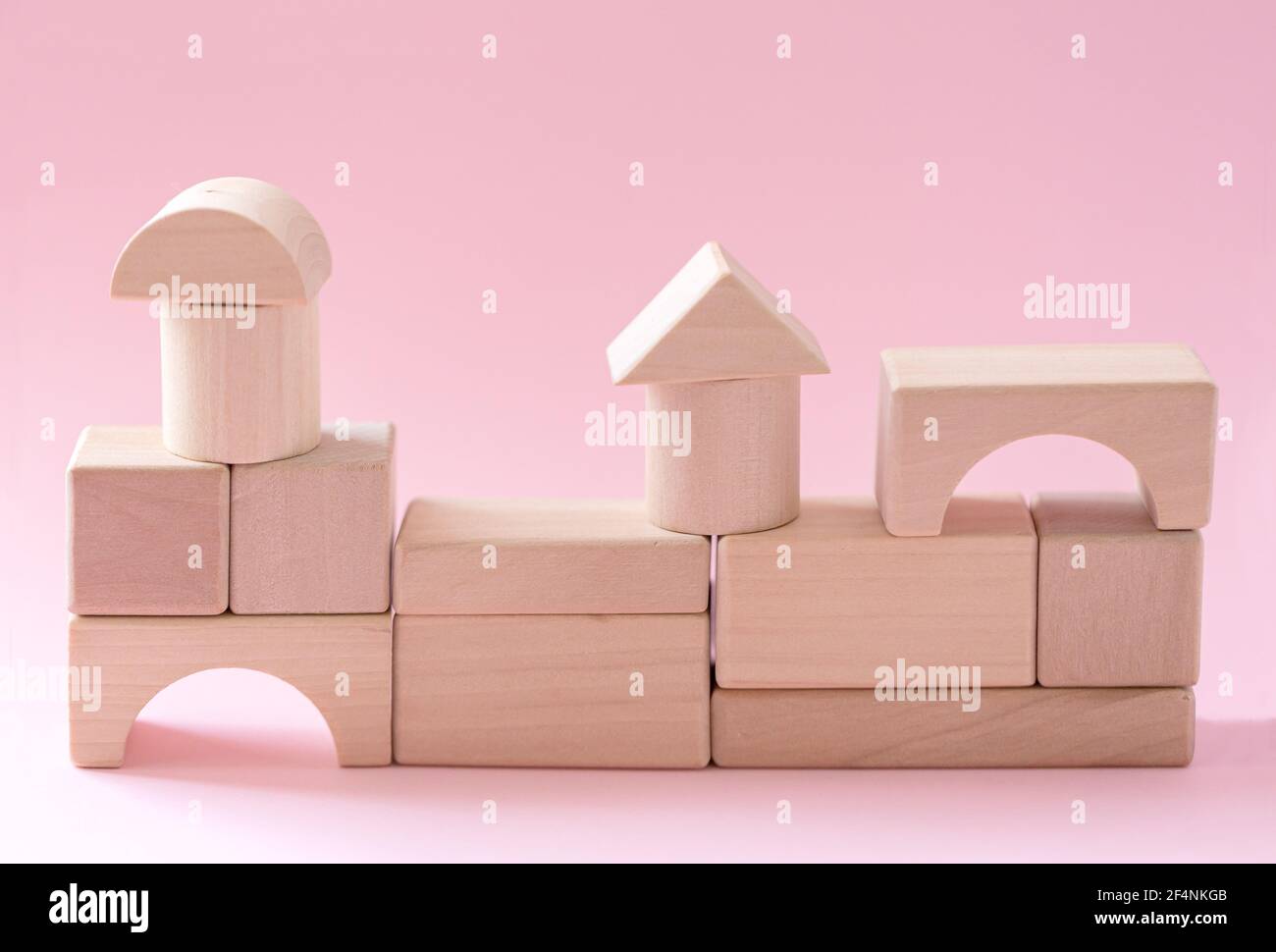 Abstract geometric real wooden cube with surreal layout on pink background Stock Photo