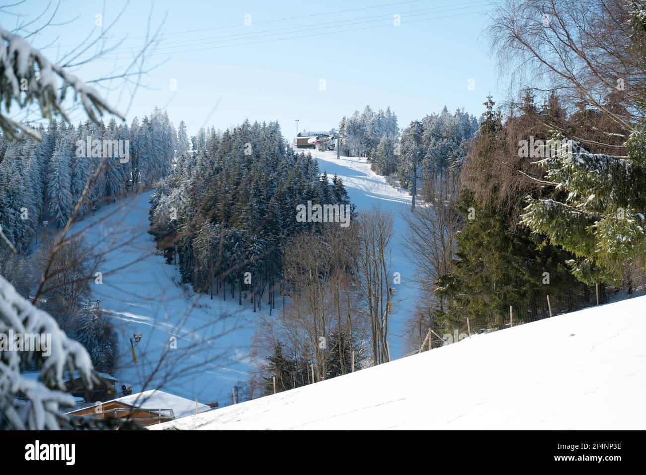 Winter sports slopes at the ski lift carousel Winterberg. Sledding slope and ski slopes between snow covered spruce forests. Stock Photo