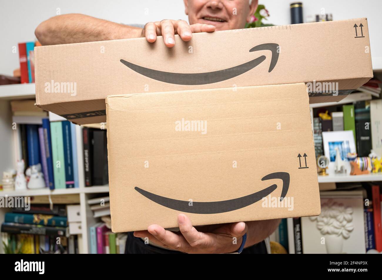 Senior man holding two new Amazon Prime parcel logotype with the smiling  arrow - the internet congolomerate founded by Jeff Bezos founding Amazon in  a Stock Photo - Alamy