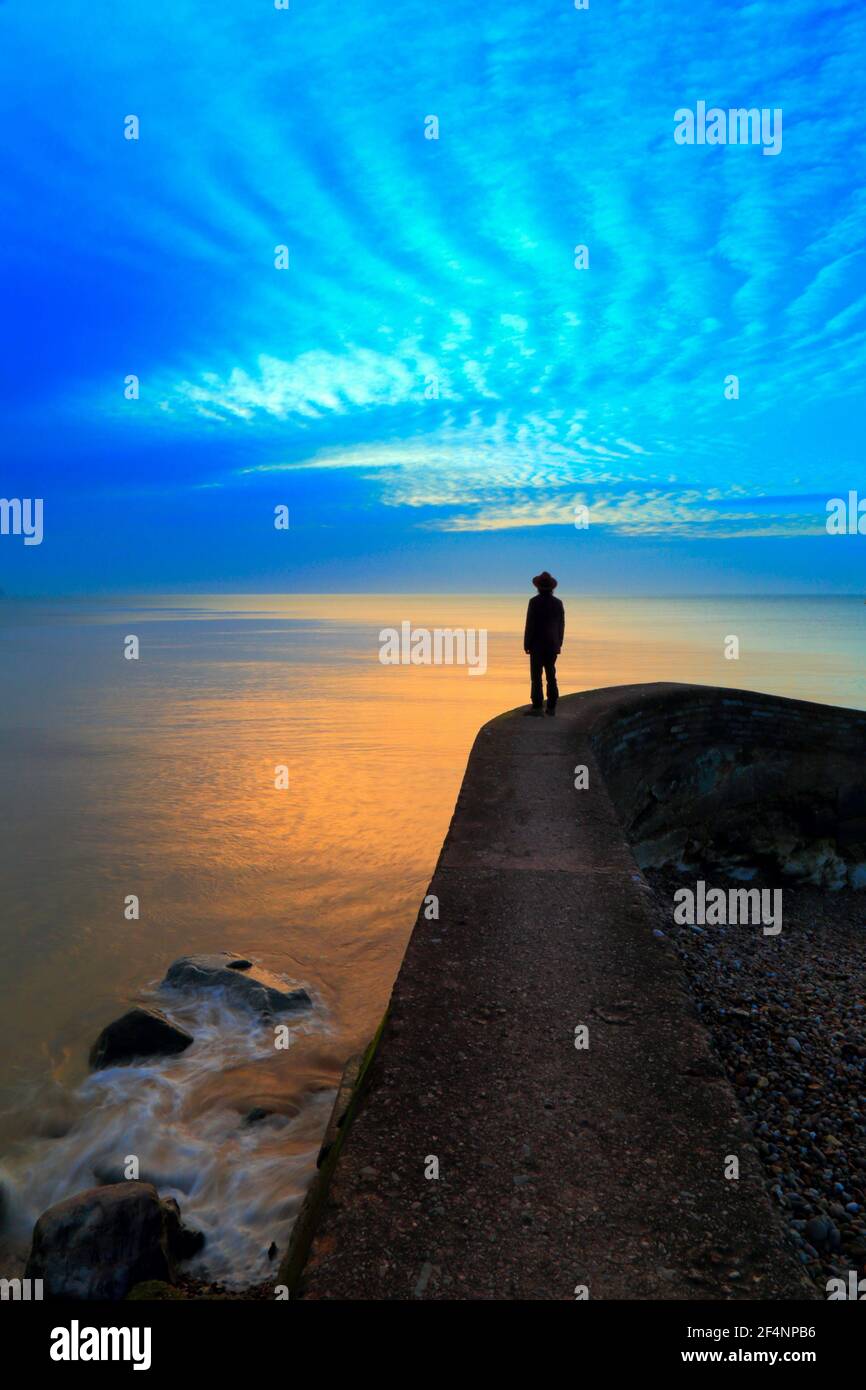 Silhouette of a man standing on jetty at sunrise. Book cover concept. Stock Photo
