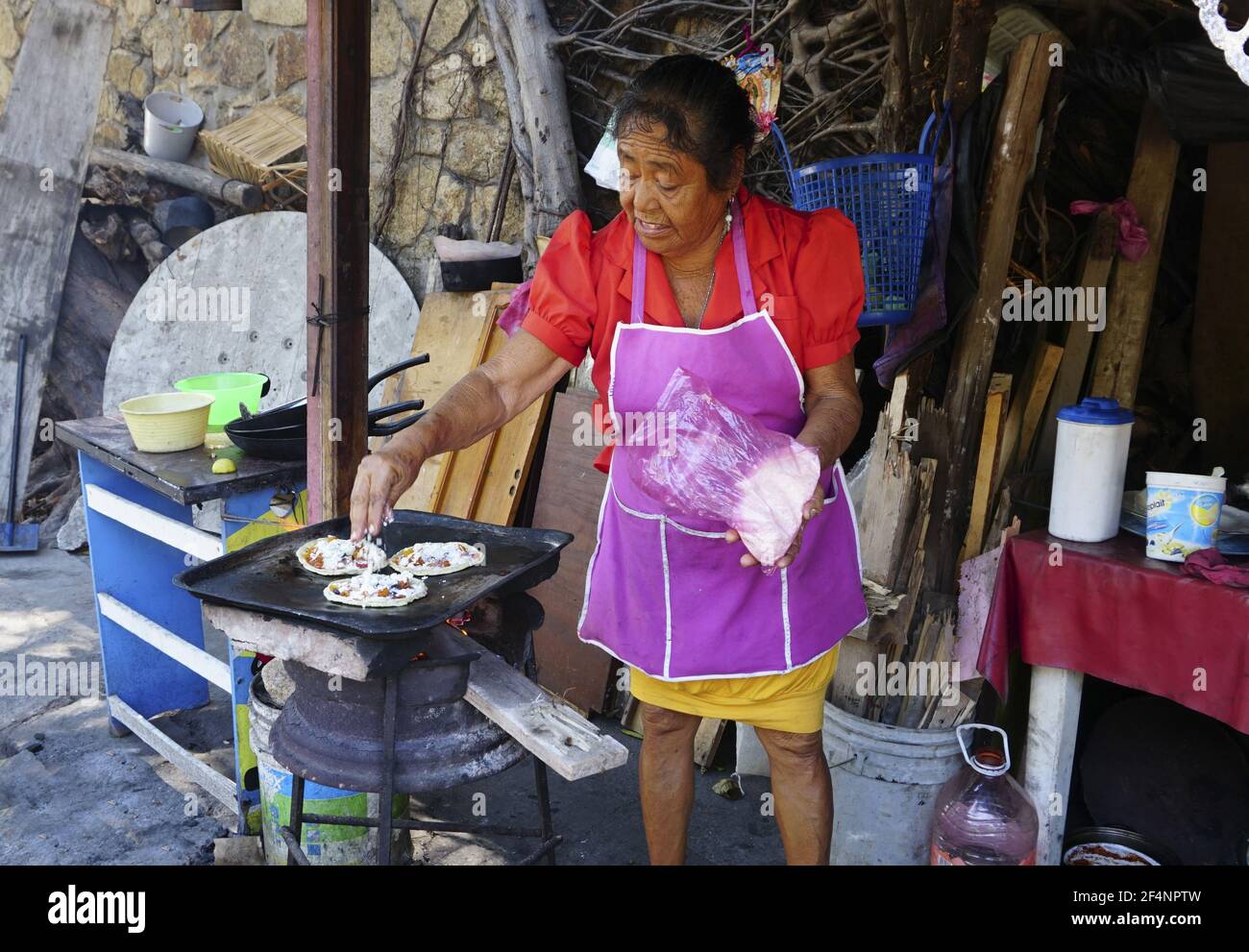 Female hispanic street vendor making sopes in Acapulco, Mexico. Stock Photo