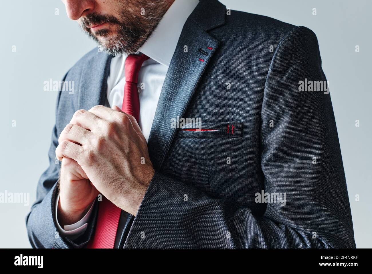 Concerned businessman with folded hands for anticipation body language concept Stock Photo