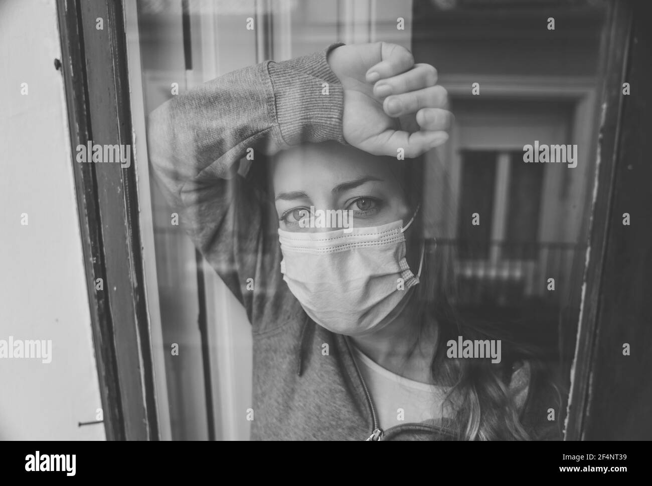 Young beautiful depressed unhappy caucasian woman looking worried and sad through the window at home. Feeling worthless and in pain. closeup. Depressi Stock Photo