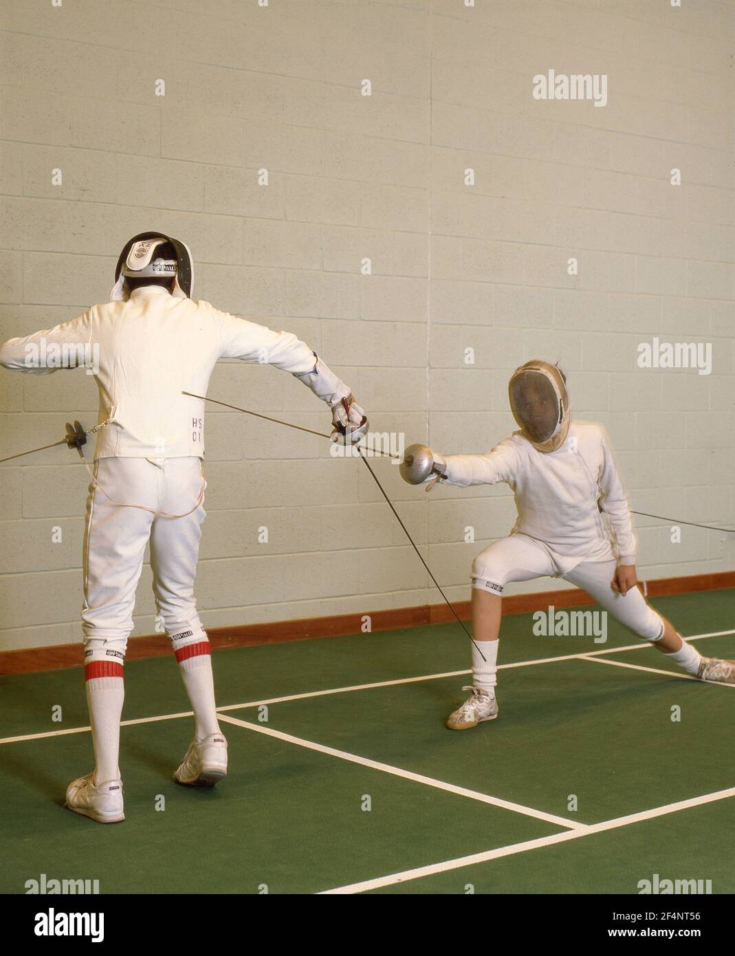 School boys fencing in school gym, Surrey, England, United Kingdom Stock Photo