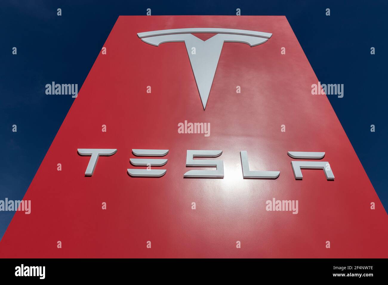 Indianapolis - Circa March 2021: Tesla electric vehicles logo. Tesla products include electric cars, battery energy storage and solar panels. Stock Photo