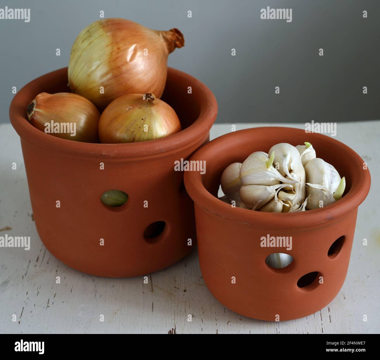 onions and garlic in brown ceramic pots Stock Photo