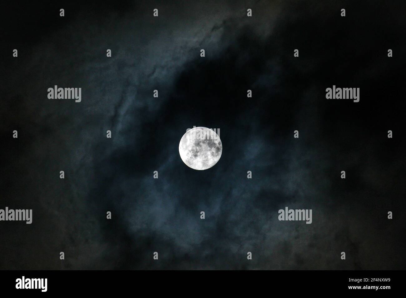 Full moon on cloudy winter night sky. Stock Photo