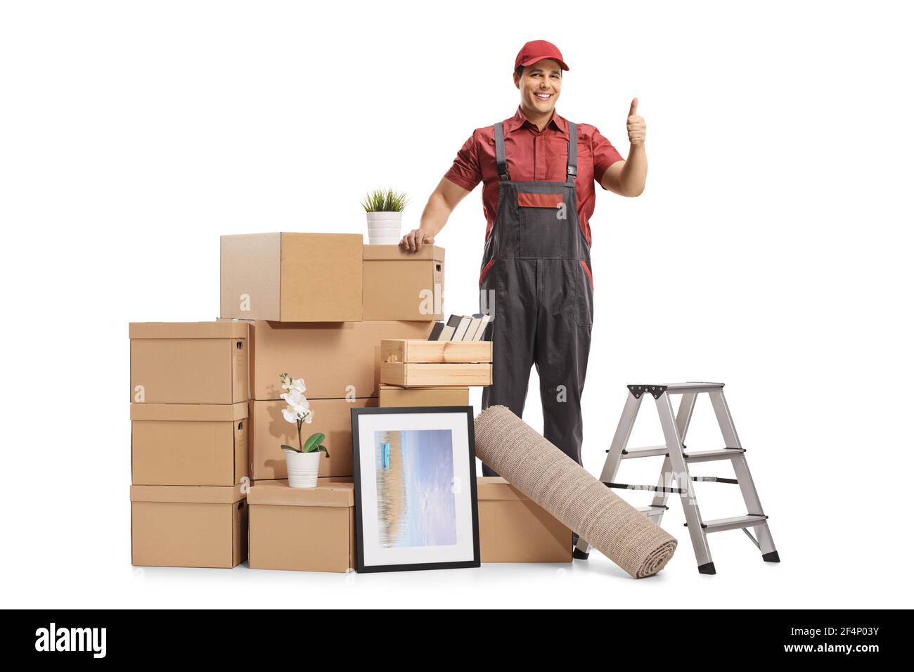 Mover posing with a pile of packed cardboard boxes for removal and showing thumbs up isolated on white background Stock Photo