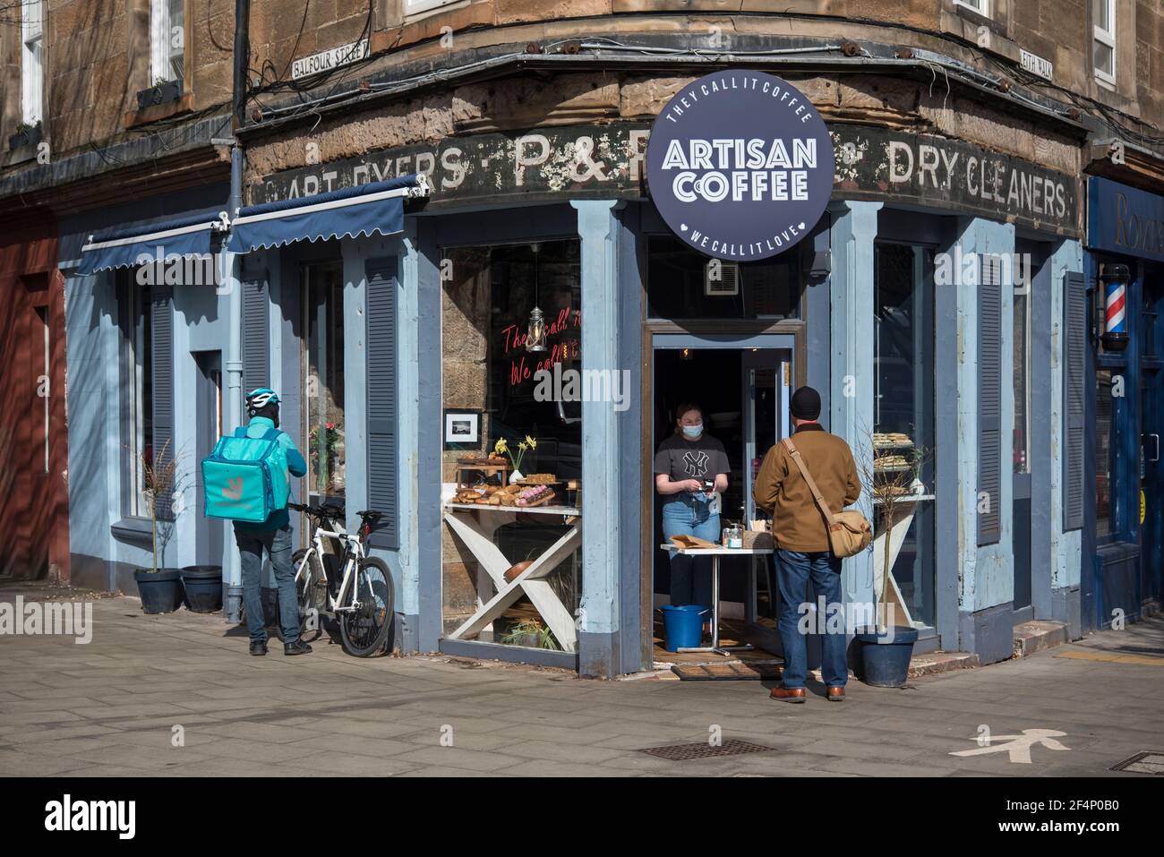 Customer being served at the door of Artisan Coffee on Leith Walk, Edinburgh, Scotland during the covid-19 pandemic. Stock Photo