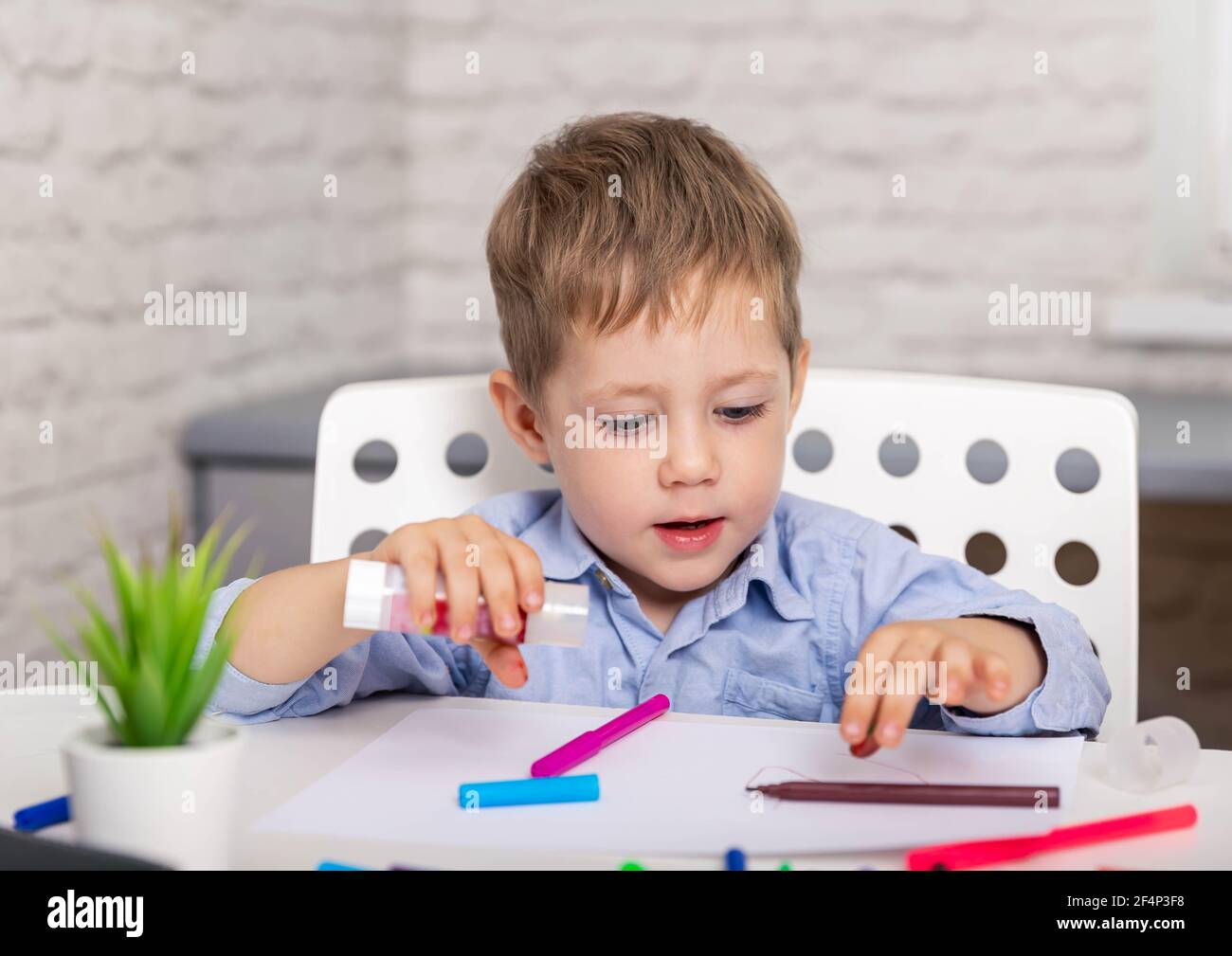 Boy cutting colored paper with scissors Stock Photo - Alamy