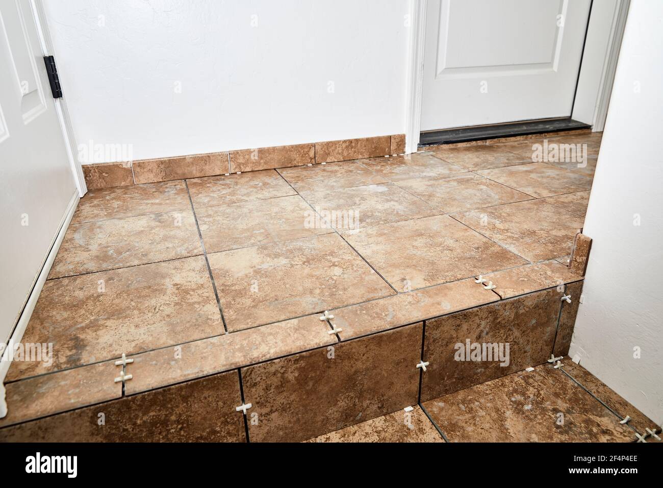 New tile installation on steps with a landing in preparation to be grouted Stock Photo Alamy