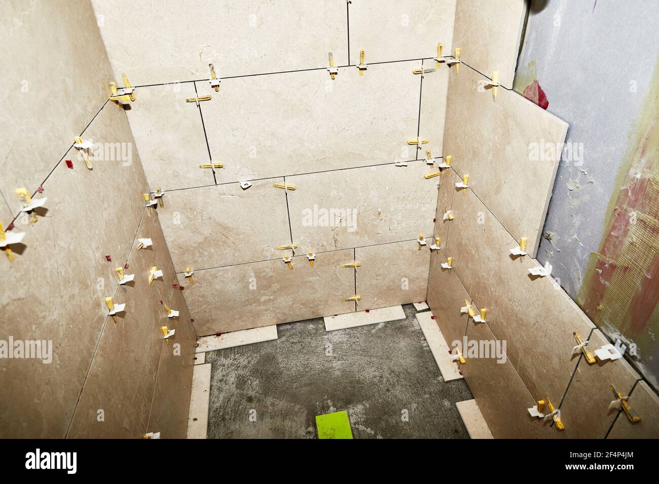 shower stall wall with grout spacers in preparation for new porcelain tile installation Stock Photo