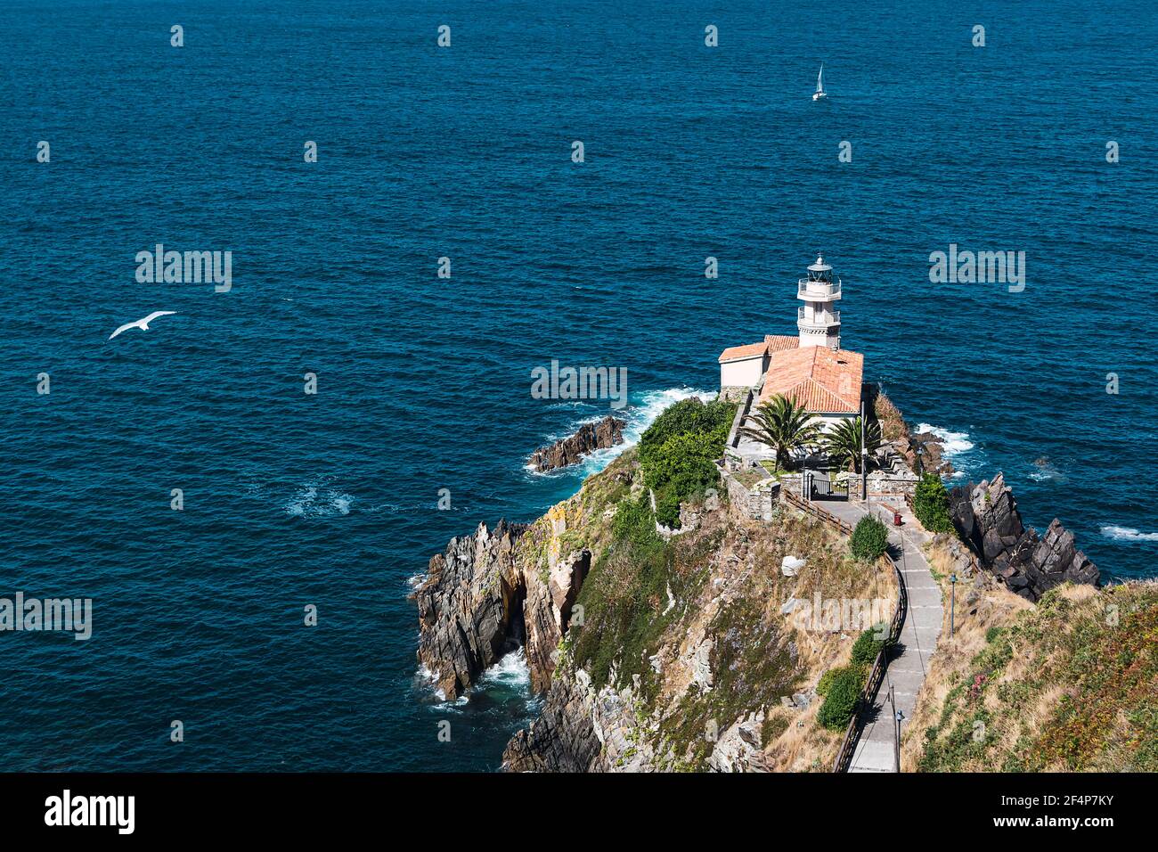 Landscape of the Cantabrian sea and the lighthouse of Cudillero, a typical coastal town of Asturias that is located in the north of Spain Stock Photo
