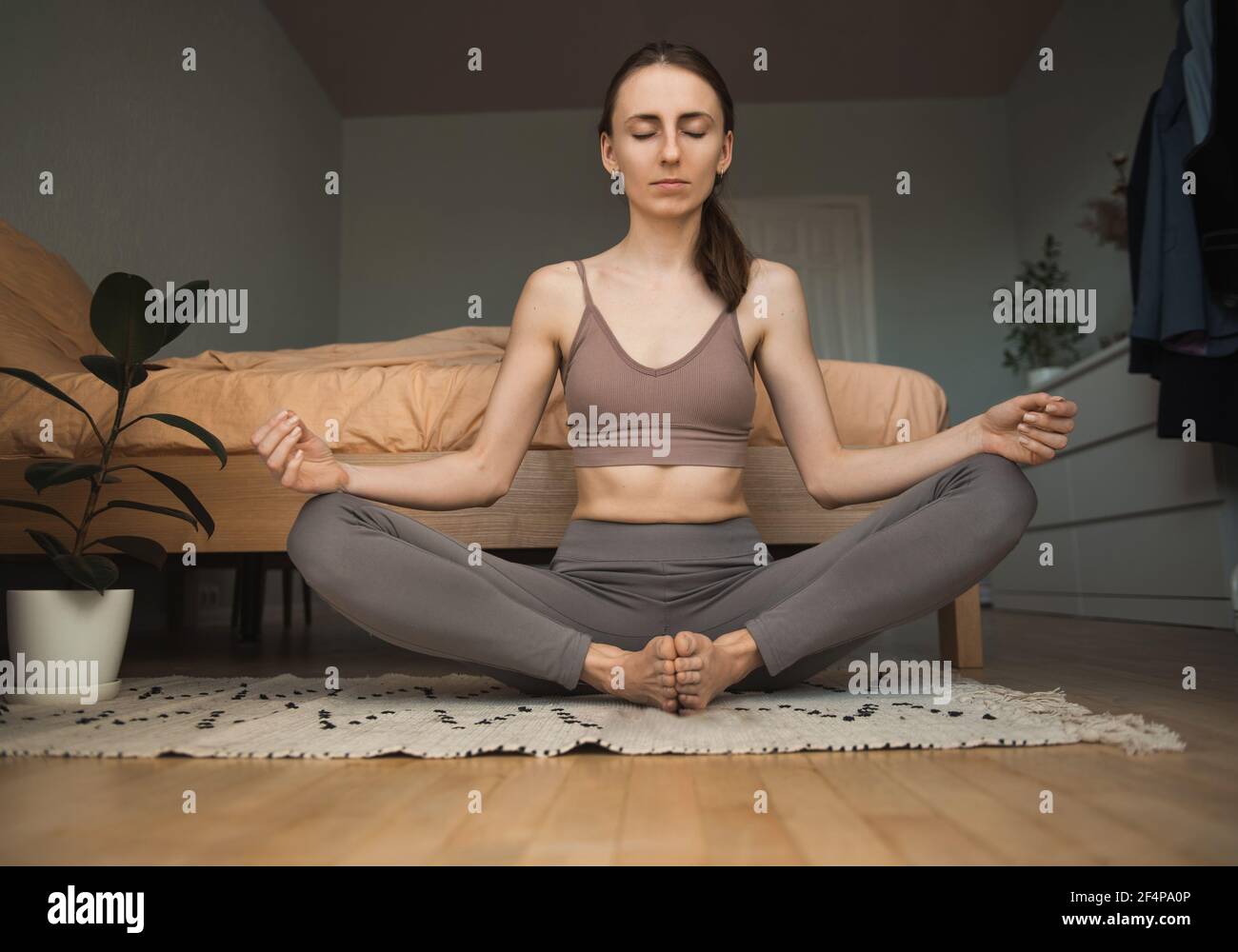 Young woman in the lotus position meditating at home Stock Photo - Alamy