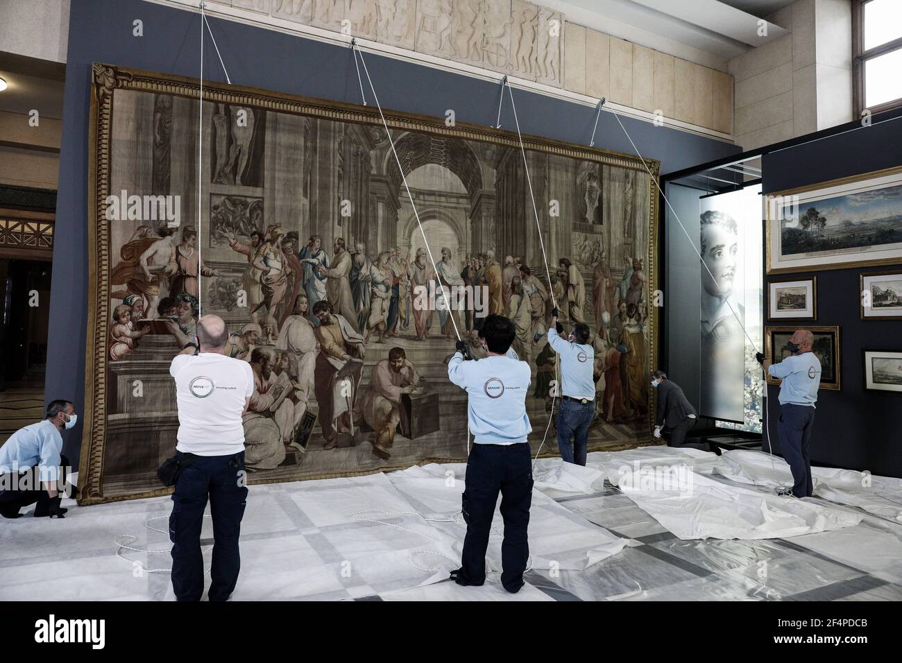 Athens, Greece. 22nd Mar 2021. Workers hang a tapestry depicting School of Athens inside the Greek parliament in Athens, Greece, on March 22, 2021. A rare 18th century tapestry depicting Italian Renaissance artist Raphael's masterpiece School of Athens was put on display in the Greek Parliament on Monday. The work, a reproduction of Raphael's fresco inside the Vatican Museum, has been loaned to Greece on the occasion of the 200th anniversary of the beginning of the Greek War of Independence, which will be celebrated this Thursday. (George Kontarinis/Eurokinissi/Handout via Xinh Stock Photo