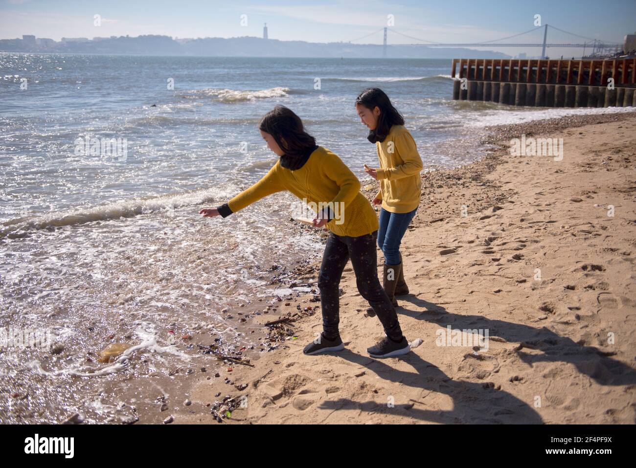 Two girls on the banks of the Teju River Throw stones into the river. Stock Photo