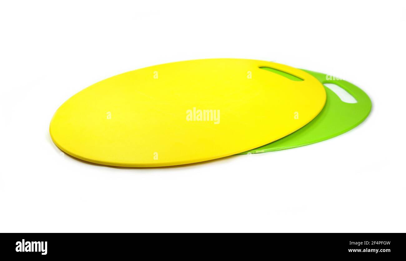 Green an yellow plastic cutting board on white background Stock Photo