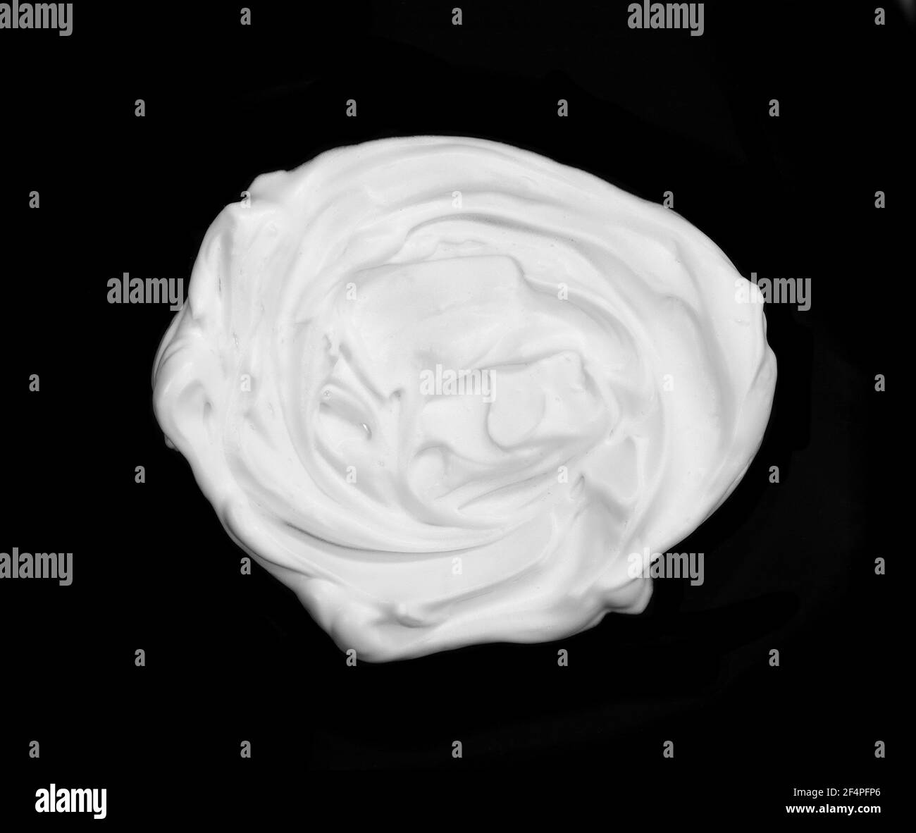 whipped cream or meringue isolated on black background. Stock Photo