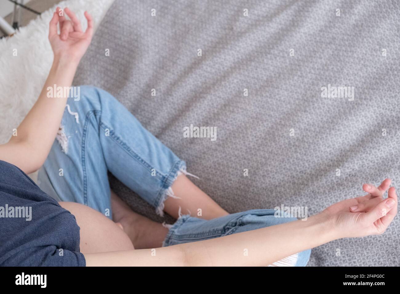 Top view of pregnant woman sitting in bed in Lotus position practicing meditation, concept HLS, yoga Stock Photo
