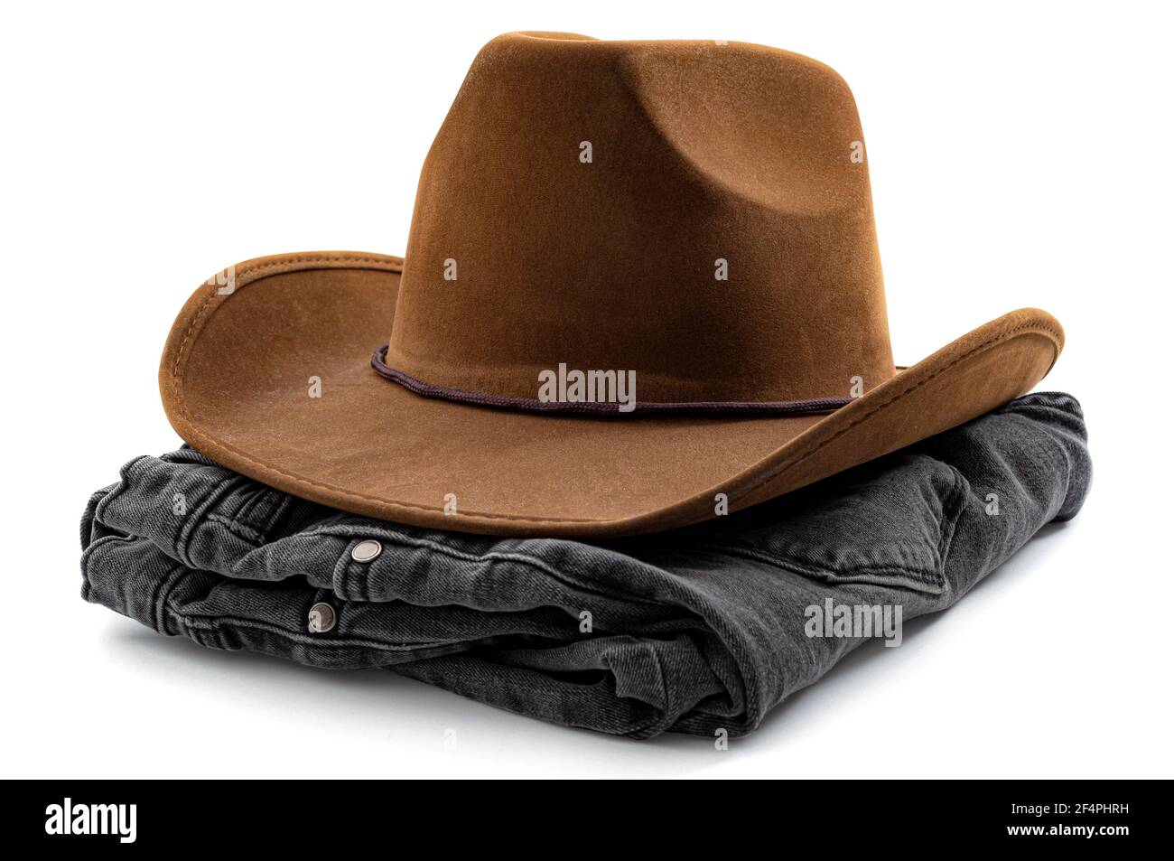 American cowboy wear, western design and country fashion conceptual idea with folded pair of black denim jeans and brown cowboy hat isolated on white Stock Photo