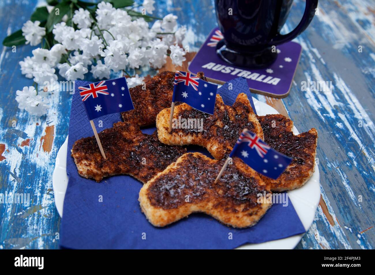 A plate of toast with vegemite, the iconic Australian savoury spread, cut into the shape of Australia as a special breakfast for Australia Day. Stock Photo