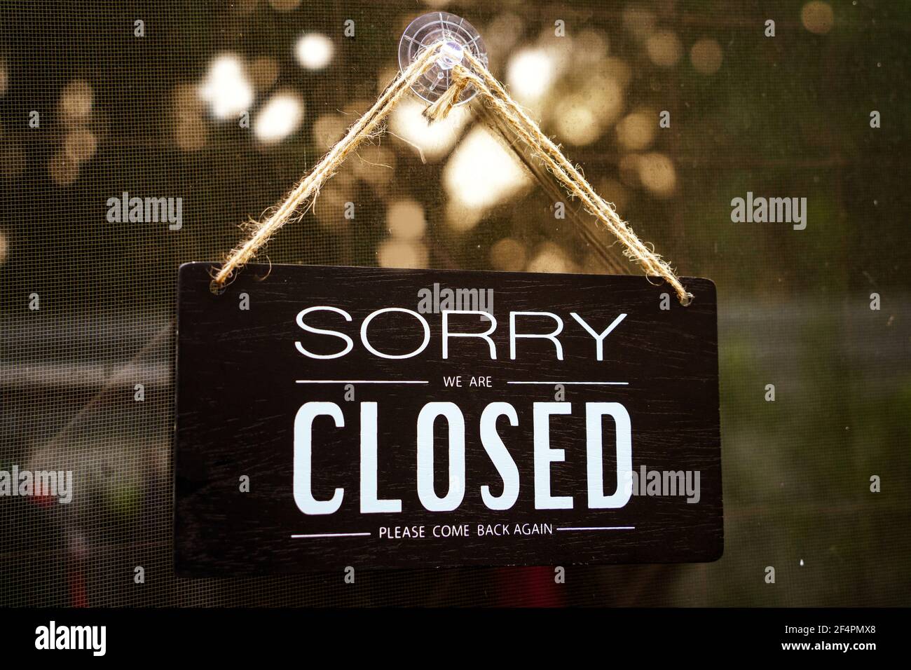 sorry we're closed . black and white wood sign on white wall - process in film tone Stock Photo