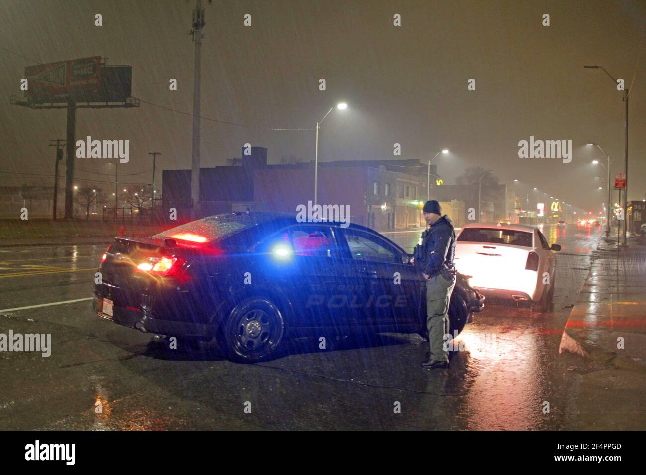 Police stop a car on a rainy night in Detroit, Michigan, USA Stock Photo
