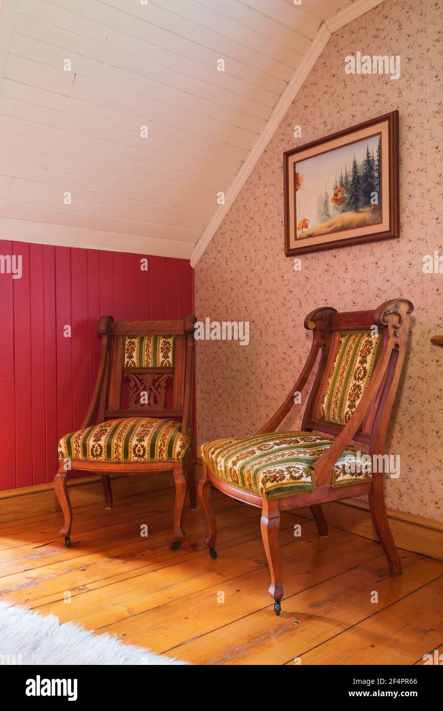 Upholstered Victorian style armchairs in guest bedroom with red and