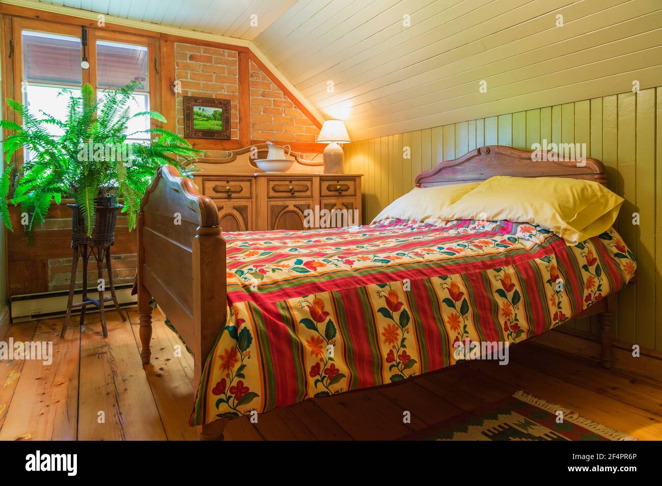 Double bed with stained maple wood headboard and footboard and red