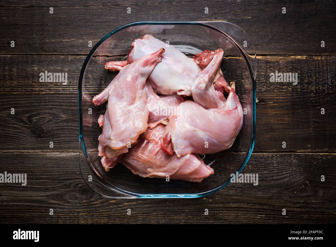 Raw rabbit meat marinated in glass bowl. Selective focus. Stock Photo