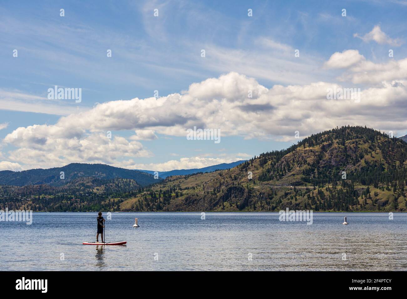 PENTICTON, CANADA - JULY 4, 2020: recreation time paddle boarding on scenic peaceful mountain lake Stock Photo