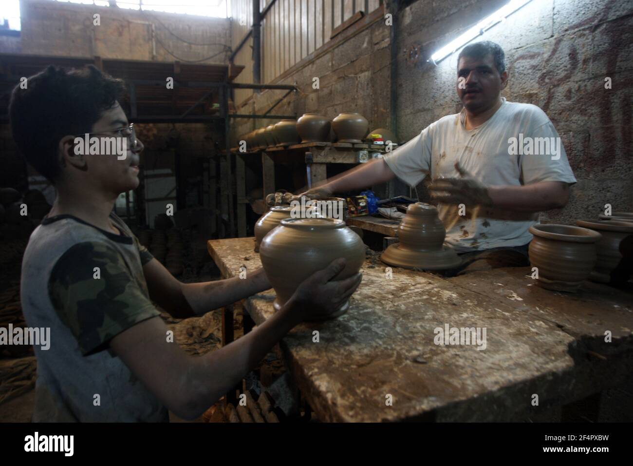 Deir Al Balah, Gaza. 22nd Mar, 2021. Palestinian potter Sid Atallah (R) and one of his sons work at the family workshop in Deir al-Balah in the central Gaza Strip on Monday, March 22, 2021. Photo by Ismael Mohamad/UPI Credit: UPI/Alamy Live News Stock Photo