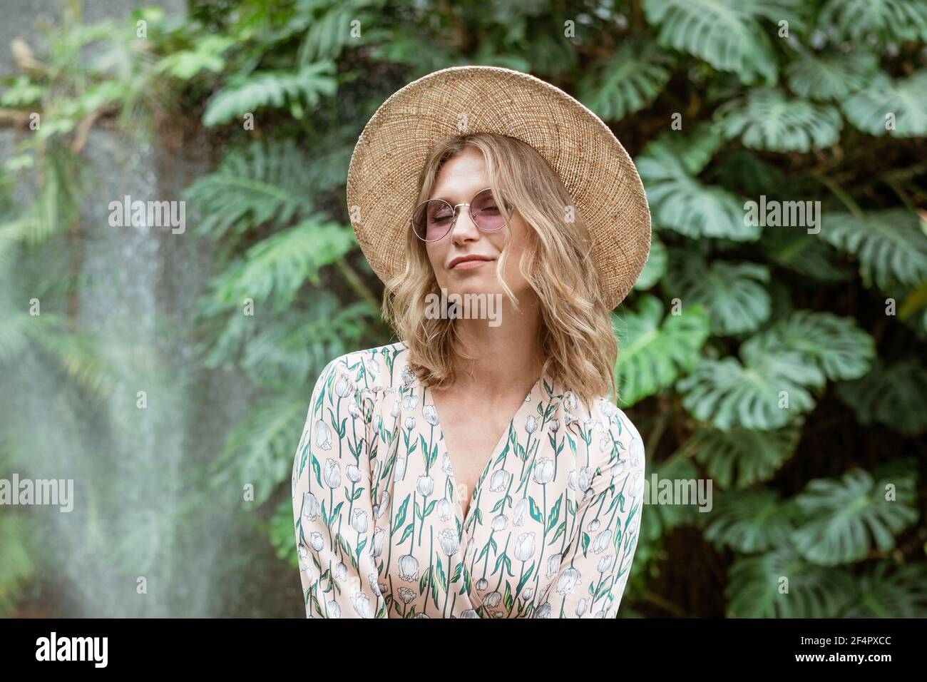 beautiful young blonde woman in a straw hat and glasses posing in the ...