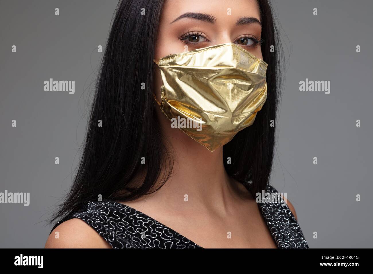 haughty woman wearing a golden face mask concept of surgical masks