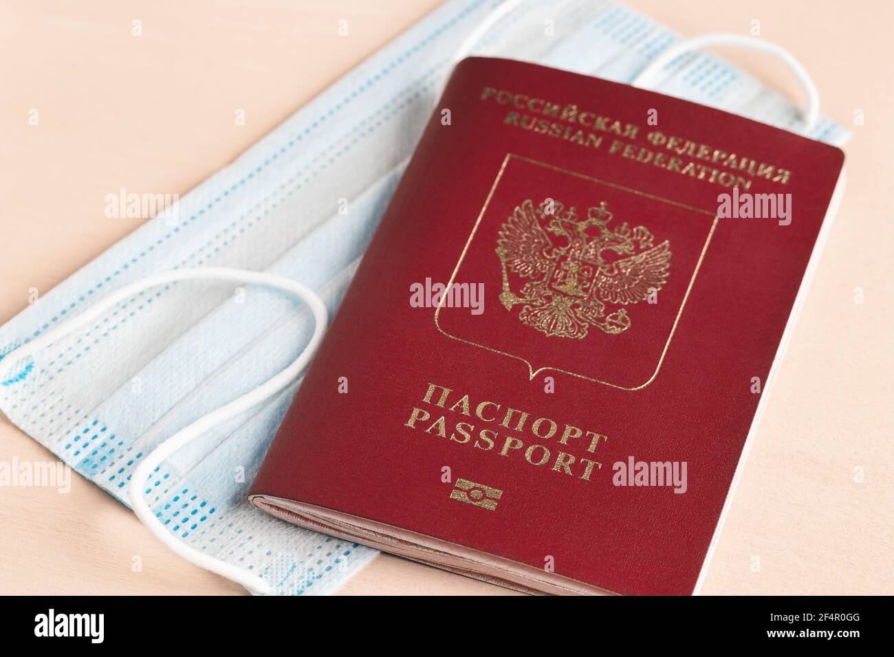 Safe travel during coronavirus pandemic concept. Protective medical mask and Russian passport on the table Stock Photo