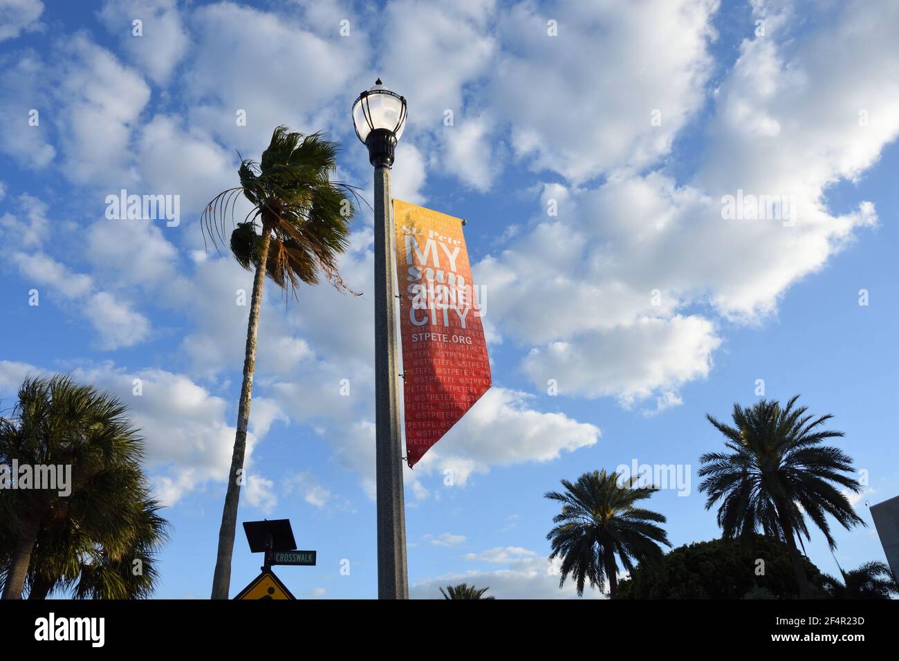 The colorful banner advertising city of St. Petersburg on the street light pole in downtown with Cumulus clouds and blue sky background, Florida,USA. Stock Photo
