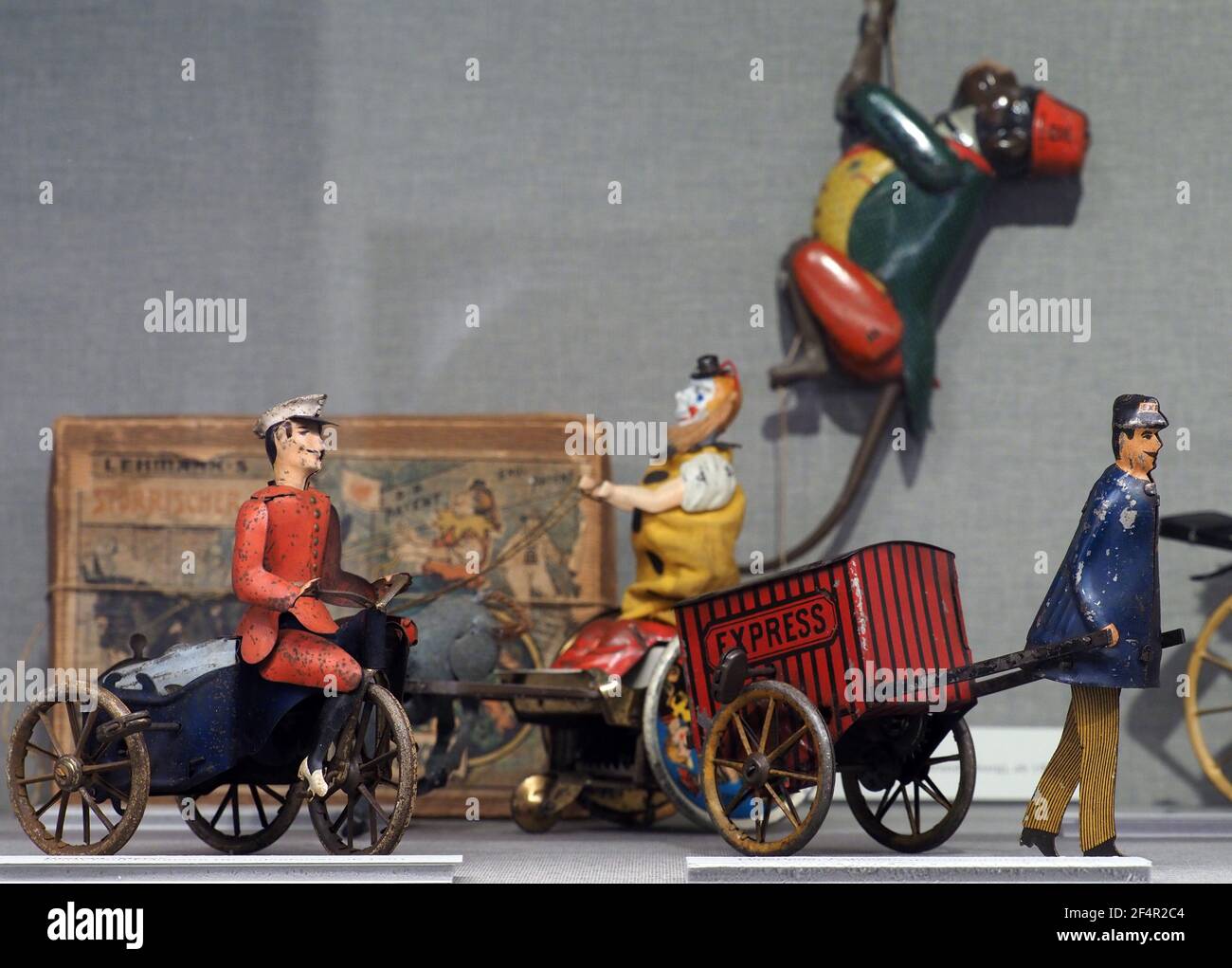22 March 2021, Brandenburg, Fernbellin/Ot Wustrau: The 'Mars' tricycle (Ernst Paul Lehmann, Brandenburg, circa 1901) and the 'Express' delivery messenger (Ernst Paul Lehmann, Brandenburg, circa 1928) are set up in a glass display case in the special exhibition '(K)ein Kinderspiel - Spielzeug als Spiegel der Industrialisierung' ((No Child's Play - Toys as a Mirror of Industrialization) in the Brandenburg-Prussia Museum. The exhibition uses many small things to show how mechanisation and population growth had an effect right into the children's room. The toy exhibition is initially designed unti Stock Photo
