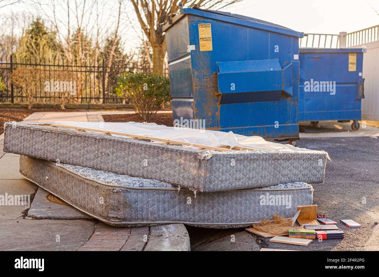 Despite regulations by the Home owners association, residents still illegally dump bulk items by the residential trash containers. Two old mattresses Stock Photo