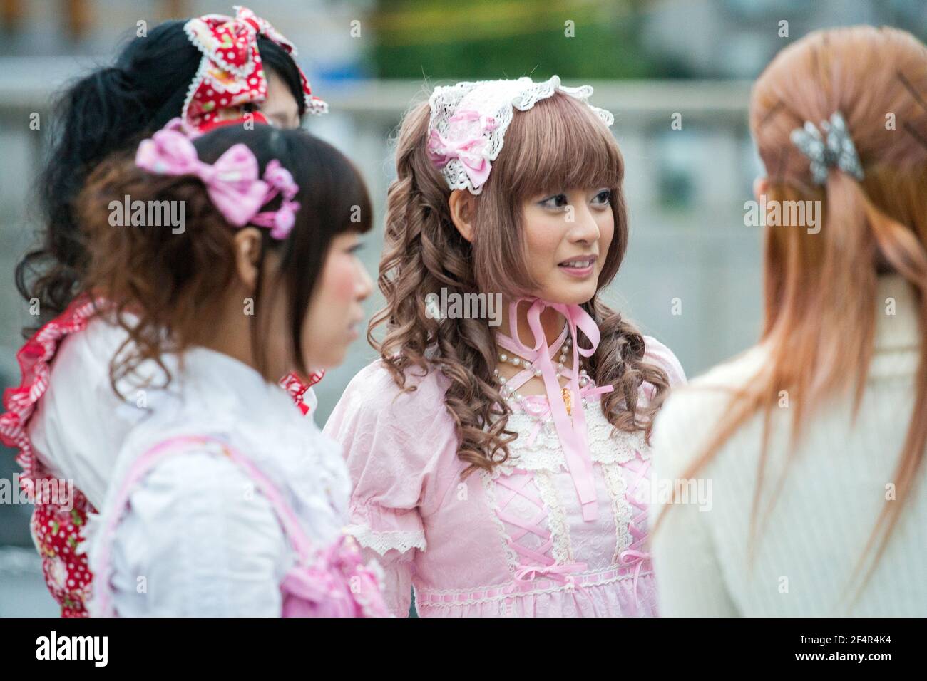 Close up of pretty Japanese lolita with ringlets and fringe wearing pink dress and headband, Harajuku, Tokyo, Japan Stock Photo