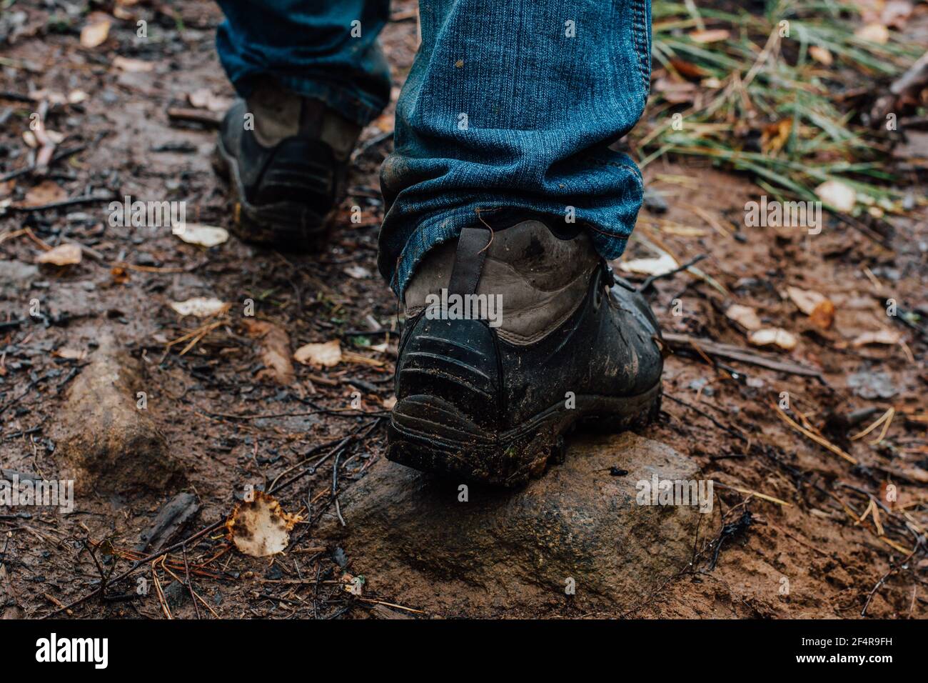 Legs of a tourist in hiking boots on a walk in the autumn along a