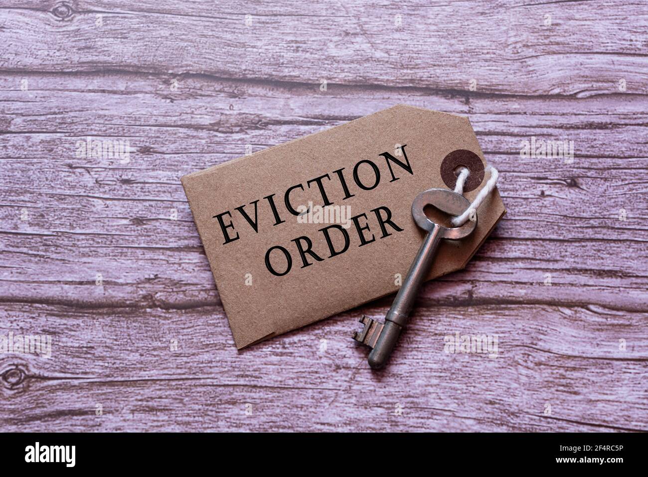 Text on brown tag with key on wooden table - Eviction order Stock Photo