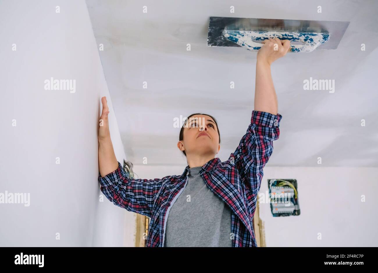 Bricklayer smoothing plaster ceiling with the trowel Stock Photo Alamy