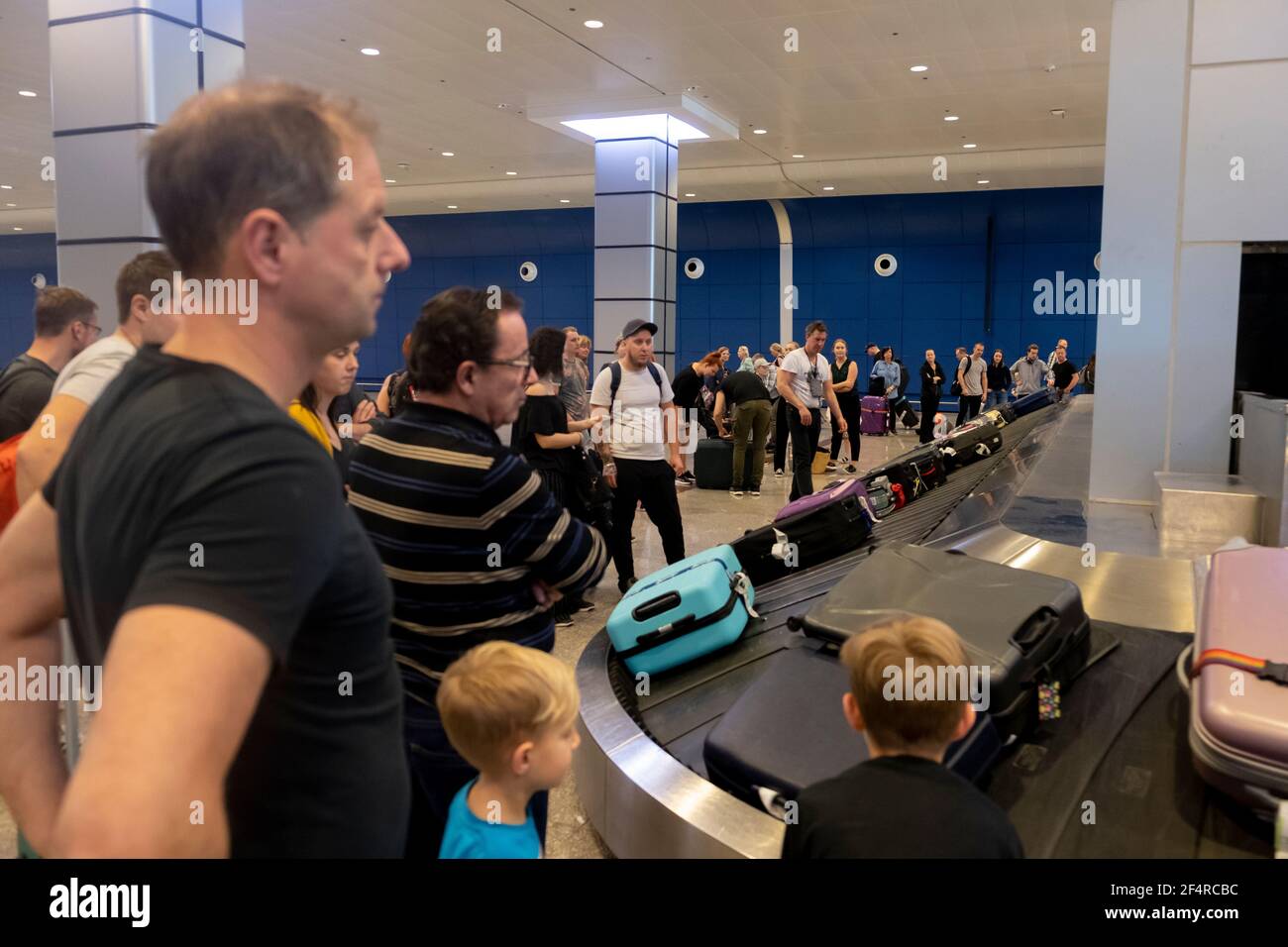 People are waiting for their luggage after landing. Stock Photo
