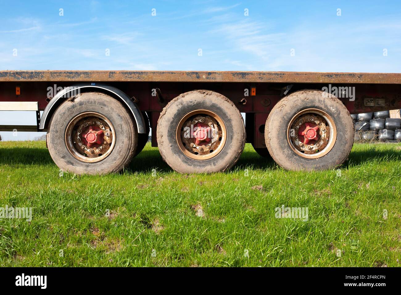 Triple axle on a flat bed trailer Stock Photo